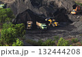 Excavator and wheel loaders loading dump trucks with raw coal in a vast open pit mine, heavy machinery extracting fossil fuel for industrial processing and power generation. Industrial concept Excavator and wheel loaders loading dump trucks with raw coal in a vast open pit mine, heavy machinery extracting fossil fuel for industrial processing and power generation. Industrial concept 132444208
