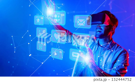Man in Virtual Reality Headset Engaging with Interactive Digital Interface, Exploring Futuristic Technology and Social Media Concepts in Vibrant Colorful Lights. Raster 132444752