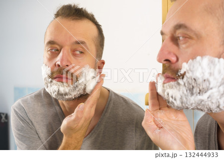Guy shaving his beard in bathroom 132444933