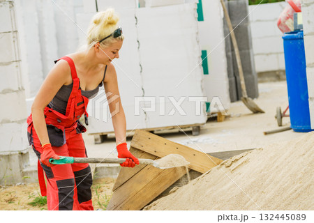 Woman using shovel on constriction site 132445089