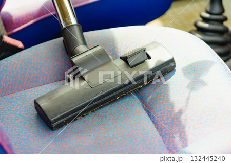 Cleaning car interior with vacuum cleaner 132445240