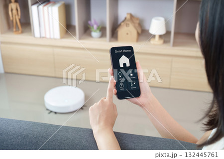Smart Home Management. User controlling devices with smartphone app. 132445761