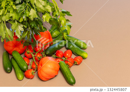 Fresh parsley tomatoes and cucumbers on clean surface arranged with copy space on the right 132445807