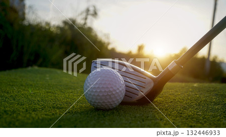 Golf clubs and balls on a green lawn in a beautiful golf course with morning sunshine. Golf clubs and balls on a green lawn in a beautiful golf course with morning sunshine. 132446933