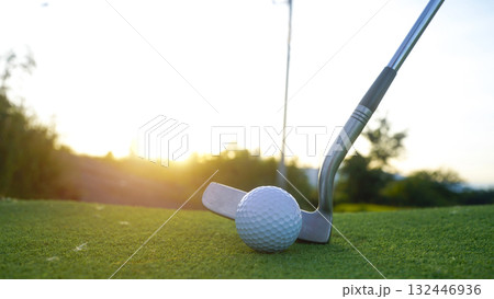 Golf clubs and balls on a green lawn in a beautiful golf course with morning sunshine. 132446936