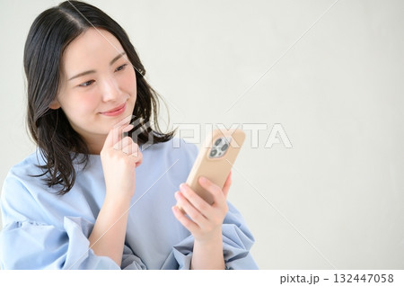 スマホを見て悩む日本人女性 132447058