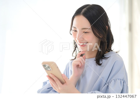 スマホを見て悩む日本人女性 132447067
