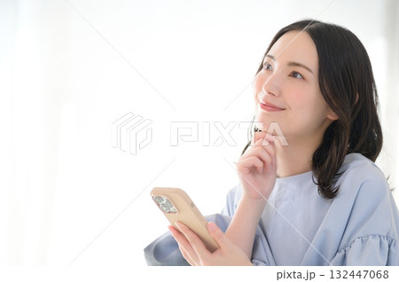 スマホを見て悩む日本人女性 132447068