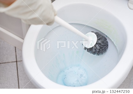 A man washes a toilet. He cleans the toilet to maintain cleanliness and hygiene A man washes a toilet. He cleans the toilet to maintain cleanliness and hygiene 132447250