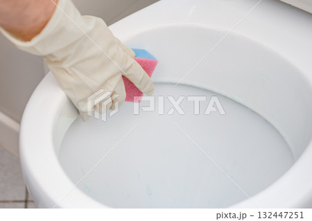 A man washes a toilet. He cleans the toilet to maintain cleanliness and hygiene A man washes a toilet. He cleans the toilet to maintain cleanliness and hygiene 132447251