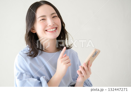 スマホを持ってカメラ目線の日本人女性 132447271