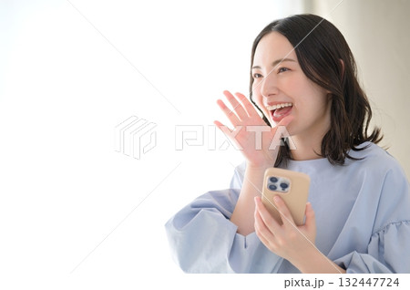 スマホを持って呼びかける日本人女性 スマホを持って呼びかける日本人女性 132447724