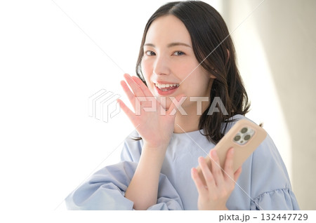 スマホを持って呼びかける日本人女性 132447729