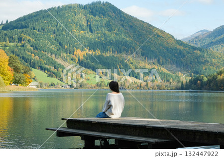 Woman Sitting on Pier Looking at Horizon Concept of Life Meaning and Meditation 132447922
