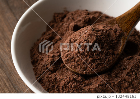 小皿の上のスプーンに載せた砂糖入りのココアの粉のクローズアップ 小皿の上のスプーンに載せた砂糖入りのココアの粉のクローズアップ 132448163