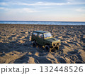 夕暮れの砂浜を走るラジコンの車 132448526