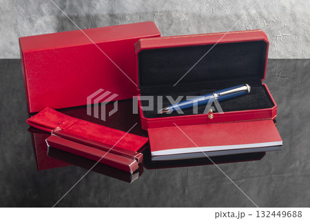 A signature fountain pen on a gray marble background. A box and case are nearby. A signature fountain pen on a gray marble background. A box and case are nearby. 132449688