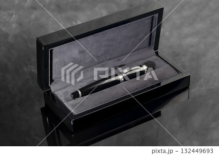 A signature fountain pen on a gray marble background. A box and case are nearby. 132449693