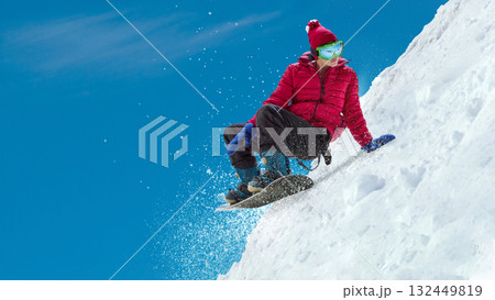 Snowboarder sliding down snowy slope creating powder spray under clear blue sky. Handmade artwork Snowboarder sliding down snowy slope creating powder spray under clear blue sky. Handmade artwork 132449819