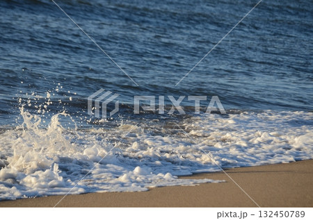 夕暮れの海に揺れる小波 — 柔らかな光に包まれた穏やかな水面 夕暮れの海に揺れる小波 — 柔らかな光に包まれた穏やかな水面 132450789