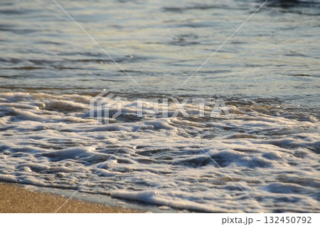 夕暮れの海に揺れる小波 — 柔らかな光に包まれた穏やかな水面 夕暮れの海に揺れる小波 — 柔らかな光に包まれた穏やかな水面 132450792