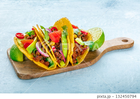 Ground beef tacos on a wooden board, Mexican food Ground beef tacos on a wooden board, Mexican food 132450794
