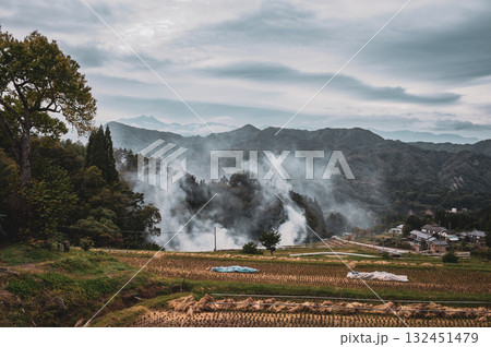 収穫後の水田と野焼きの煙【長野市大岡】 132451479