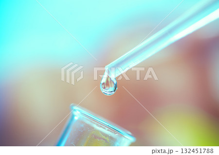 A drop of liquid drips from a pipette into a chemical tube 132451788