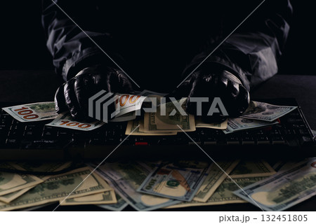 Hacker's hands on a computer keyboard rake in money Hacker's hands on a computer keyboard rake in money 132451805