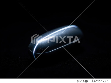 Sleek dark metallic grey pill with bright reflective light streak 132455777