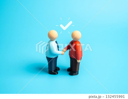Two people shake hands to signify an agreement. To reach agreement, consensus. Business partnership, cooperation, and trust-building during negotiations or contract signing. 132455991