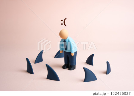 A tired office worker surrounded by shark fins. Business problems. Debt and falling income. The possibility of crisis and bankruptcy. Financial pressure, workplace stress, and corporate survival 132456027