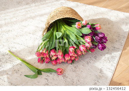 Tulips Spilling from Wicker Hat on Wooden Floor 132456412