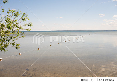 Calm lake scene with buoy line and clear skies Calm lake scene with buoy line and clear skies 132456483