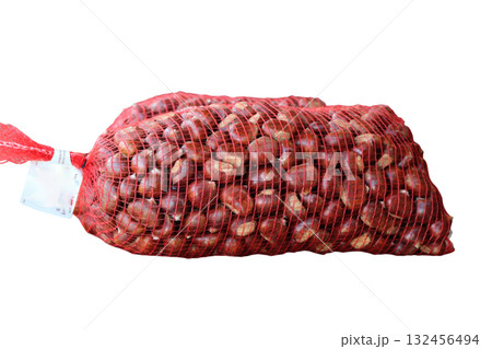 Chestnuts filling red mesh produce bag isolated Chestnuts filling red mesh produce bag isolated 132456494