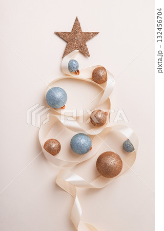 Minimalist Christmas Tree Made of Ribbon and Ornaments on Light Background Minimalist Christmas Tree Made of Ribbon and Ornaments on Light Background 132456704