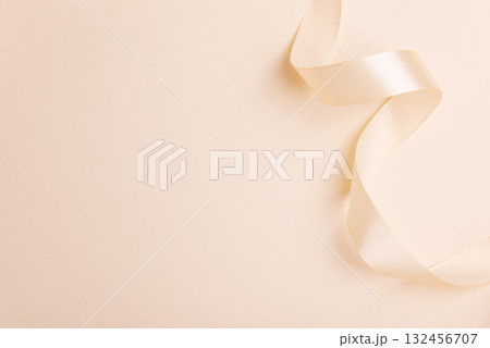 Elegant Satin Ribbon on Beige Background for Festive Design Elegant Satin Ribbon on Beige Background for Festive Design 132456707