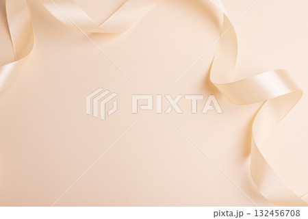 Elegant Satin Ribbon on Beige Background for Festive Design Elegant Satin Ribbon on Beige Background for Festive Design 132456708