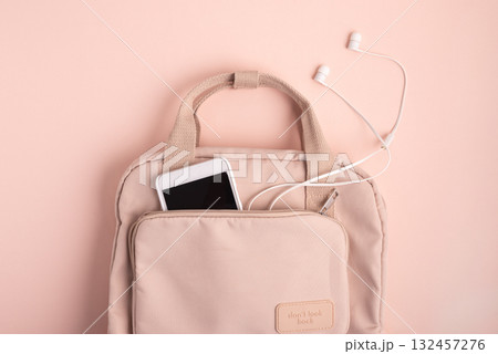 Minimalist Pink Backpack with Smartphone and Earphones on Matching Background 132457276