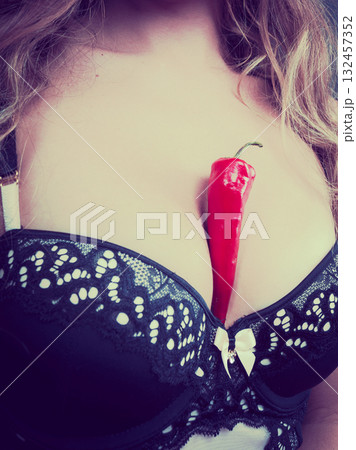 Woman wearing lingerie holding chilli pepper 132457352