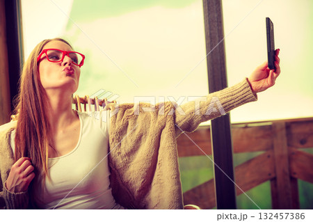 Woman sitting on chair making selfie at home Woman sitting on chair making selfie at home 132457386