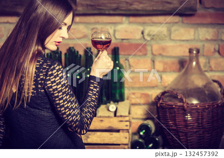 Woman tasting wine in rural cottage interior Woman tasting wine in rural cottage interior 132457392