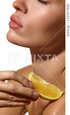 Close-up woman face with lemon slice on shoulder isolated on white background. Close-up woman face with lemon slice on shoulder isolated on white background. 132457680