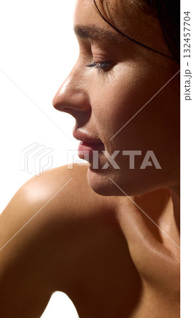 Profile of young woman with radiant skin and calm emotion in soft light 132457704