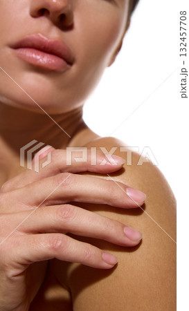 Woman touching bare shoulder showing soft hydrated skin and calm mood Woman touching bare shoulder showing soft hydrated skin and calm mood 132457708