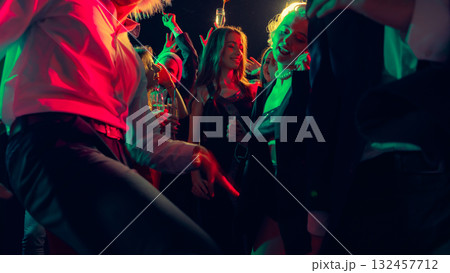 Dancing crowd in Christmas party with champagne and bright red-green lights Dancing crowd in Christmas party with champagne and bright red-green lights 132457712