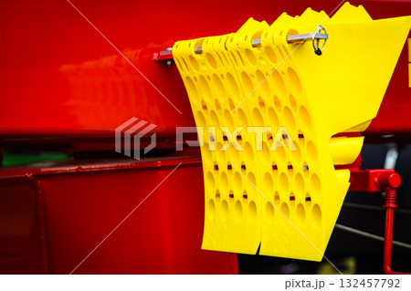 Yellow brake stop blocks wedges on red tractor 132457792