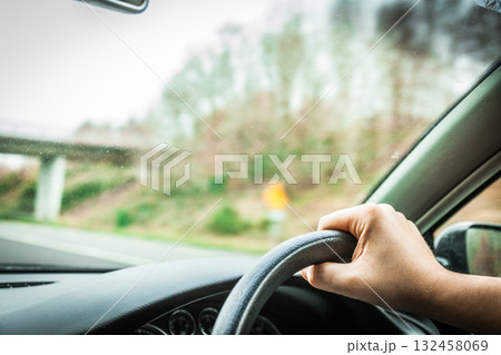 Male driver hands on steering wheel of a car and road Male driver hands on steering wheel of a car and road 132458069