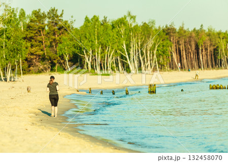 Woman in sportswear running through seaside Woman in sportswear running through seaside 132458070