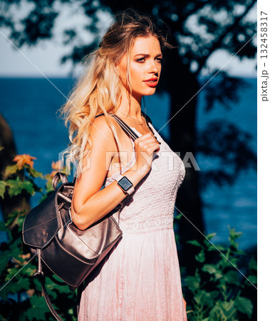 Casual girl with backpack on sea coast 132458317
